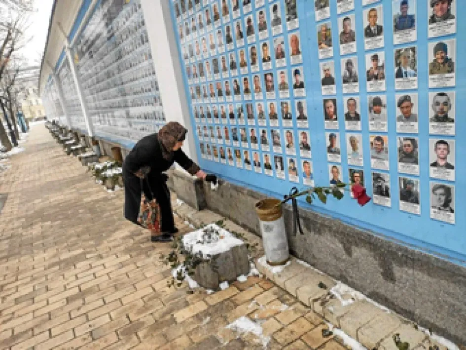 Una señora limpia las lozas de un mural de homenaje a los soldados y milicianos ucranianos caídos desde la invasión de Rusia en el 2014, en el Monasterio de San Miguel de las Cúpulas Doradas en Kyiv.