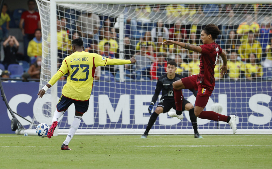 El colombiano Jorge Cabezas patea para anotar el segundo tanto de su selección ante los venezolanos.