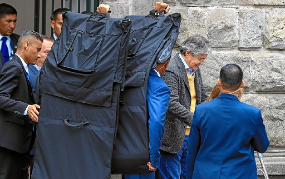 El presidente de Ecuador, Guillermo Lasso, sale protegido con mantas antibalas del Centro Cultural Metropolitano, en Quito (Ecuador).