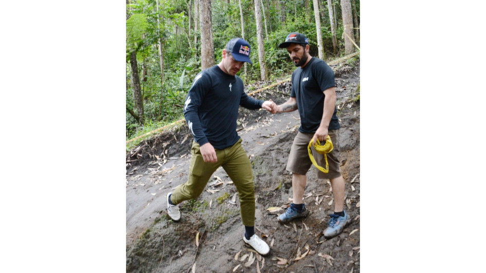 Jorge Mario Jaramillo, 'Chigüiro' (derecha), le ayuda al francés Loïc Bruni para que no se resbale sobre la pista en la que se correrá desde hoy el Downhill de las Flores.