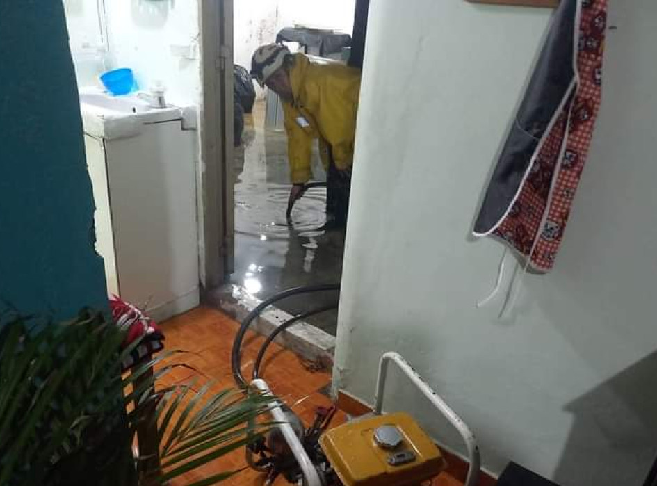 Bomberos sacan el agua que ingresó a una casa por el fuerte aguacero de la noche del miércoles en Anserma. 