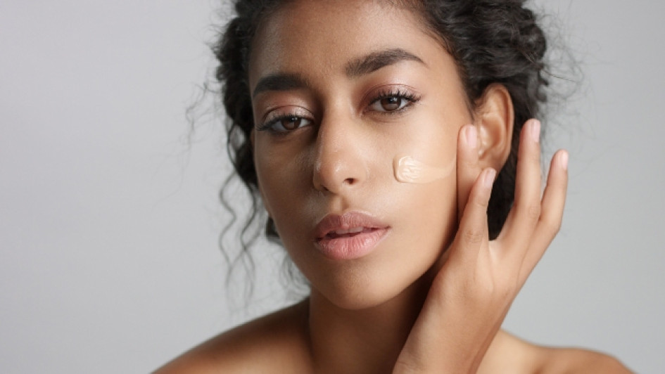 Mujer aplicándose protector solar en la cara.