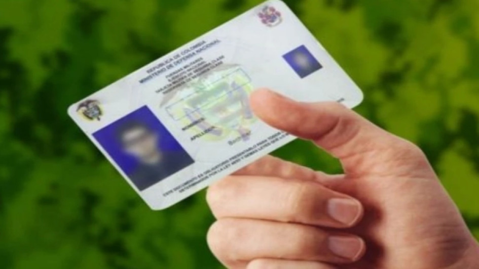 Mano sosteniendo una libreta militar colombiana.