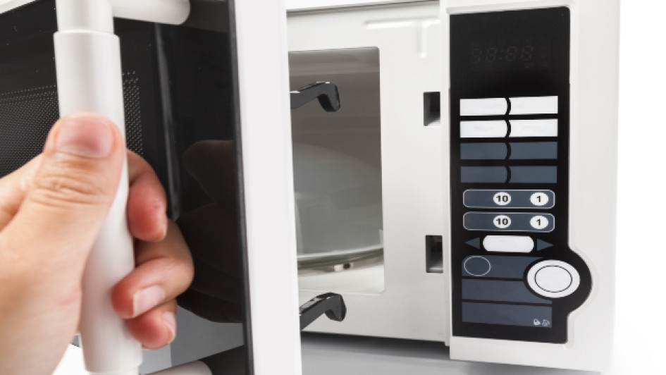 Persona abriendo un horno microondas.