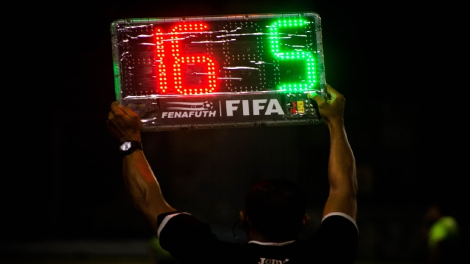 Árbitro de fútbol muestra un aviso de sustitución en un partido.