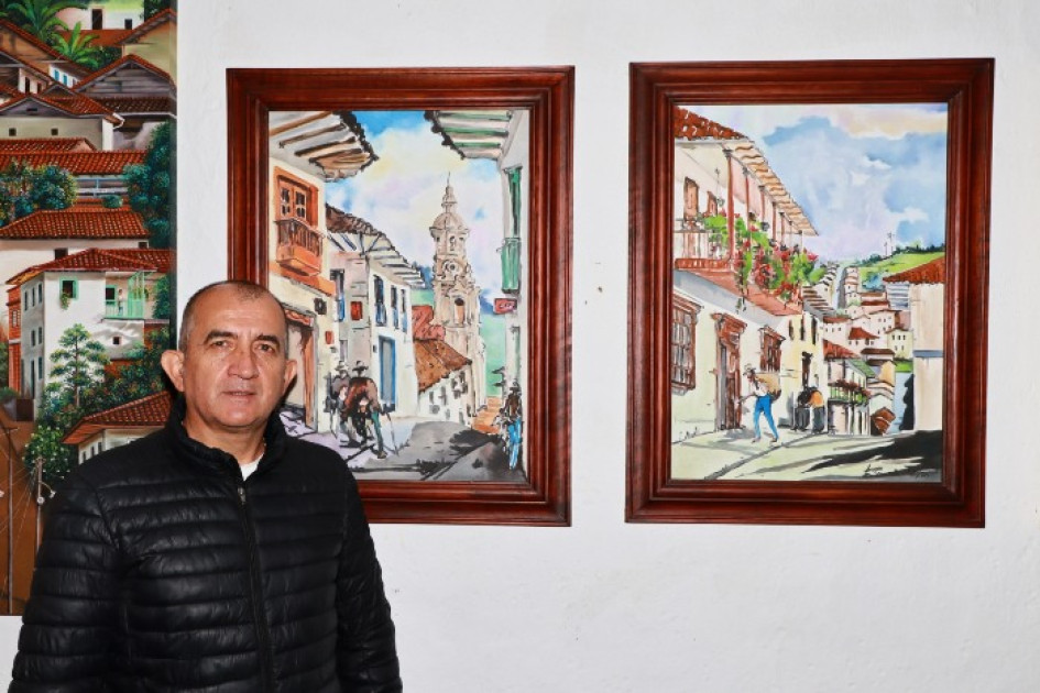 El fotógrafo salamineño Willman Vásquez con las acuarelas de Luis Hernández.