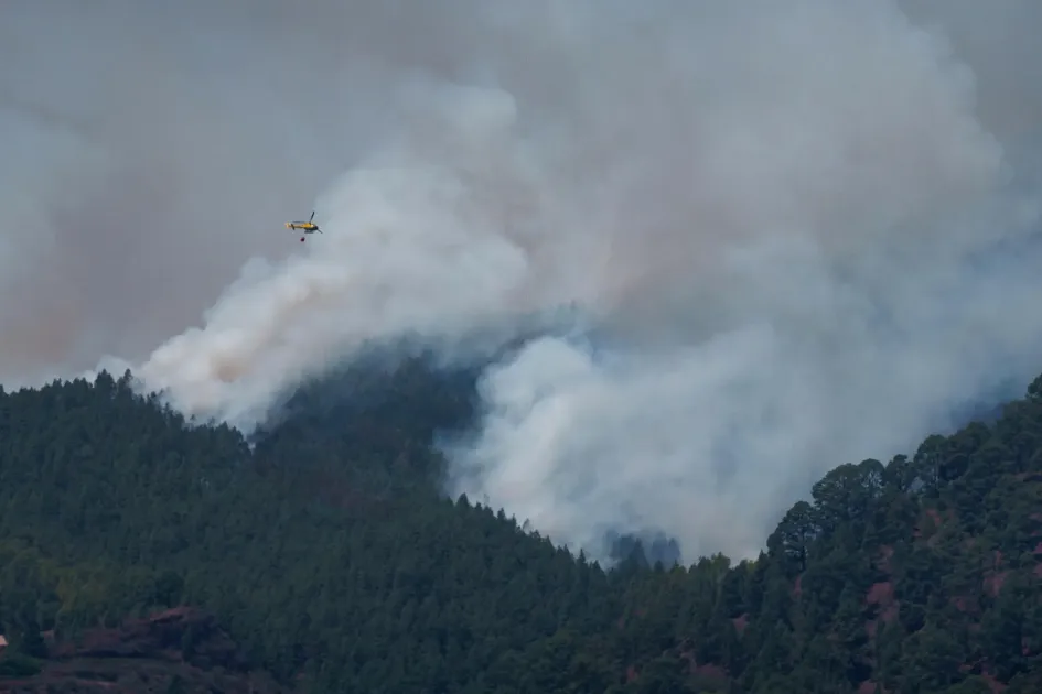 Un helicóptero trabaja en la extinción del incendio forestal en los altos de Güímar.