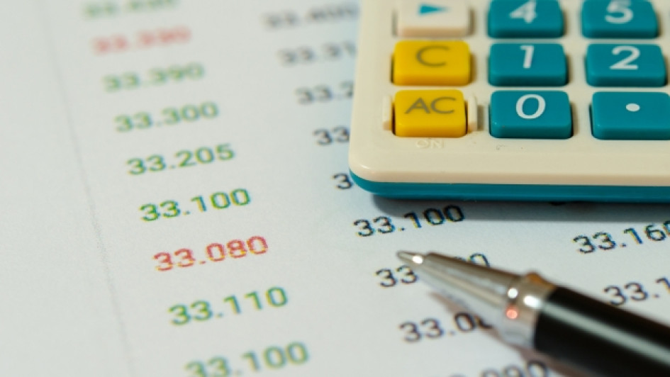 Calculadora y lapicero encima de una hoja con números.