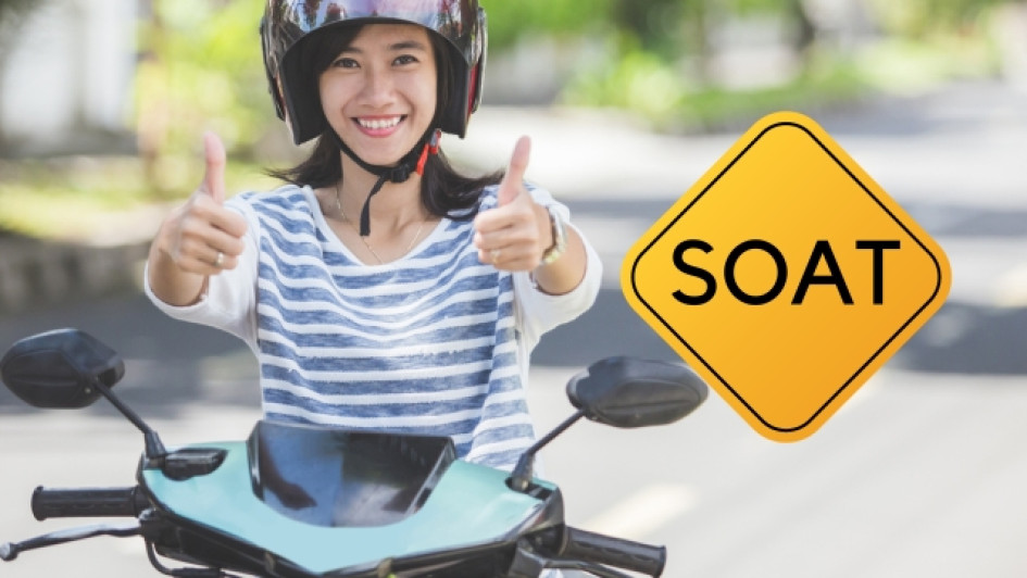Mujer en moto al lado de un aviso que dice "SOAT"