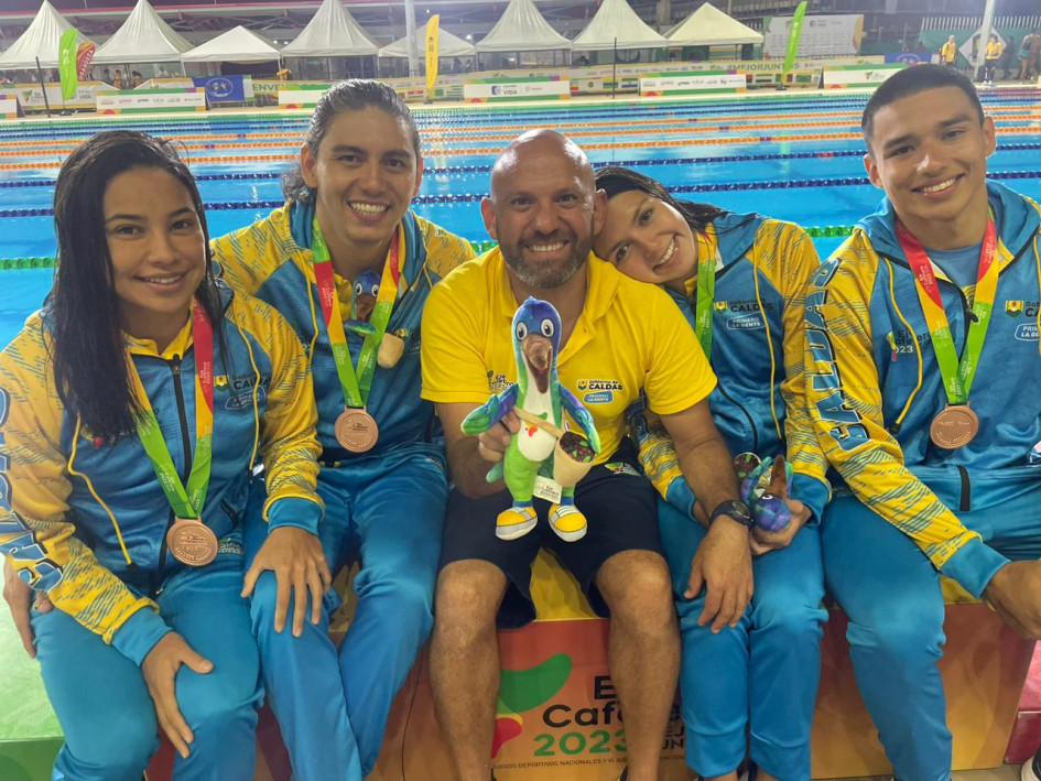 El equipo ganador de la medalla de bronce con su entrenador Andrey Parra (centro).