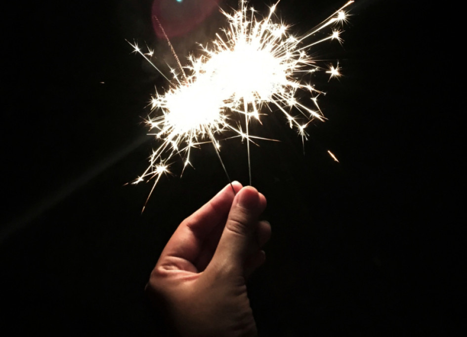 Foto gratuita primer plano de mano sosteniendo bengala con fondo negro