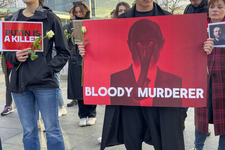 Un manifestante porta una pancarta con la consigna "Maldito asesino" y una imagen de Putin durante las protestas frente a la sede europea de las Naciones Unidas este viernes en Ginebra para homenajear al líder opositor ruso Alexei Navalni, pocas horas después de conocerse su fallecimiento en prisión. 