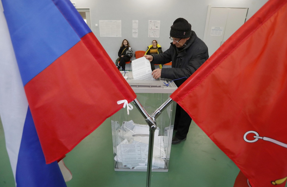 Un ciudadano ruso deposita su voto durante las elecciones presidenciales en San Petersburgo (Rusia).