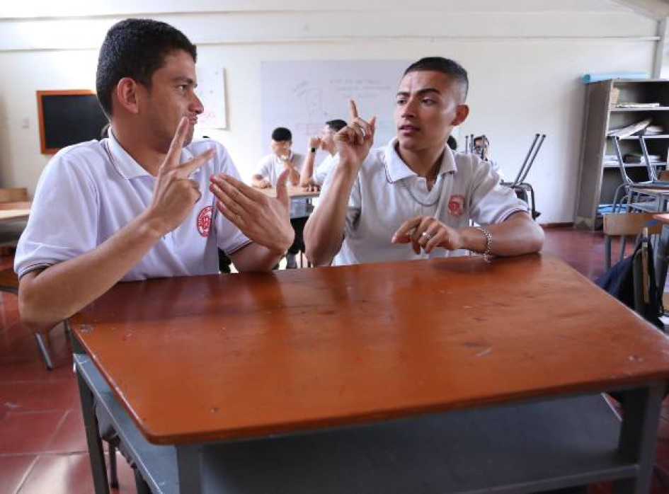 Los estudiantes sordos Daniel Felipe Soto, elegido personero, y Juan Diego Mejía, contralor, con su profesora de matemáticas, Ingrid Eliana Suárez, y la intérprete Yuri Alejandra González.