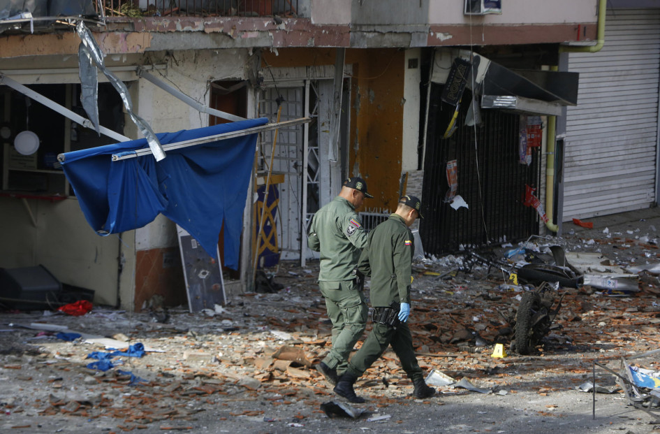  Integrantes de fuerzas de seguridad recorren el lugar donde explotó un artefacto este lunes en Jamundí (Colombia).