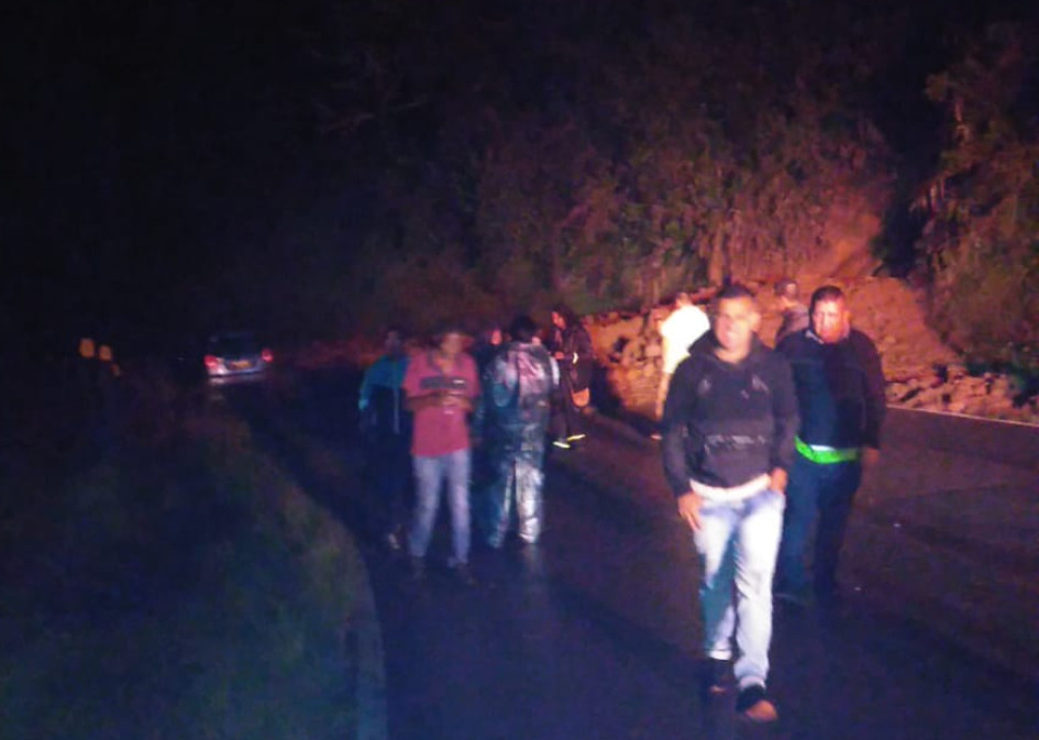 Personas caminan para alejarse del derrumbe que cayó cerca de Padua. Al fondo se ve el vehículo involucrado.