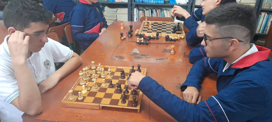 Unos 30 estudiantes se reúnen en la biblioteca para jugar ajedrez. 