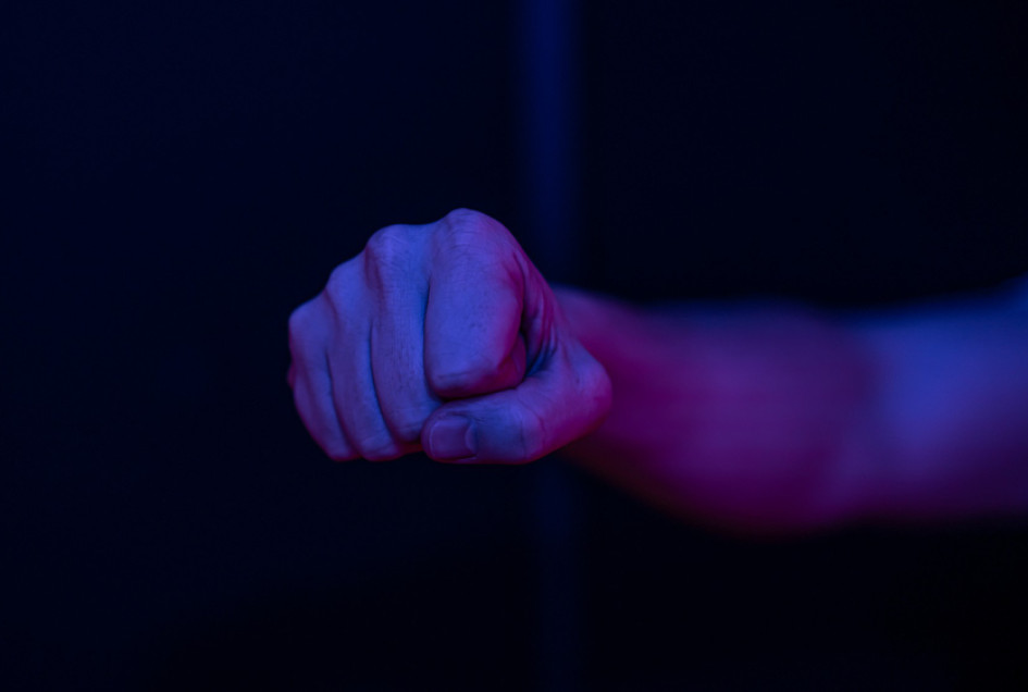 Ilustración de hombre con el puño cerrado en una pared borrosa.