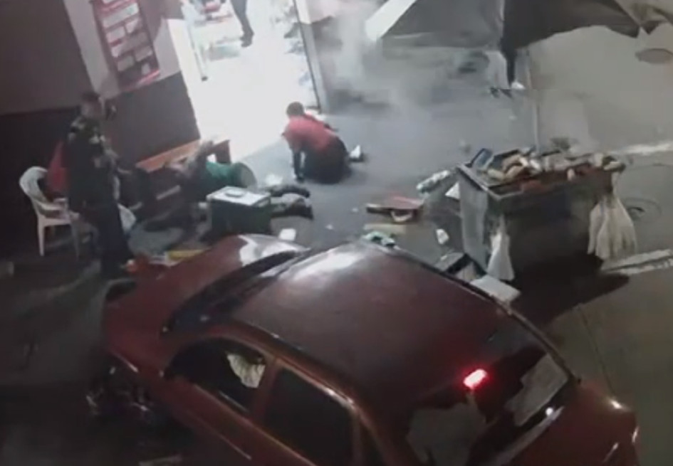 En una cámara de seguridad quedó registrado el momento en el que un carro chocó un puesto de comidas rápidas y lesionó a una persona. 
