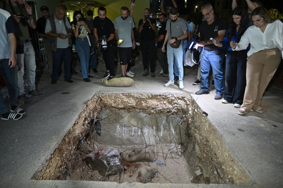 Foto / EFE / LA PATRIA La gente se encuentra cerca de un cráter después de que soldados del ejército libanés hicieran estallar un dispositivo de comunicación en el estacionamiento del Centro Médico de la Universidad Americana de Beirut.