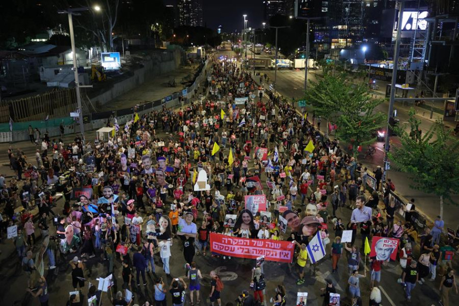 Las familias de los rehenes israelíes retenidos por Hamás en Gaza y sus partidarios portan pancartas con imágenes de sus seres queridos durante una protesta pidiendo un alto el fuego y su liberación cerca de la zona de Kirya, en Tel Aviv (Israel).