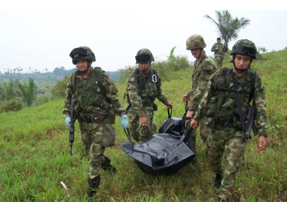 Miembros del Ejército Nacional cargan un cuerpo.