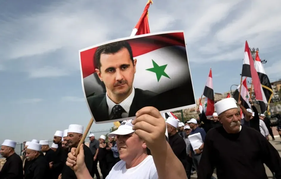 Un manifestante con una fotografía del presidente sirio, Bachar Al Assad, en la localidad drusa de Ein Qiniya. 