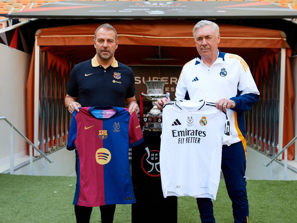 Los entrenadores del Real Madrid CF y el FC Barcelona, Carlo Ancelotti (d) y Hansi Flick (i), respectivamente, han posado este sábado junto al trofeo en el estadio Al Jawhara de Yeda. 