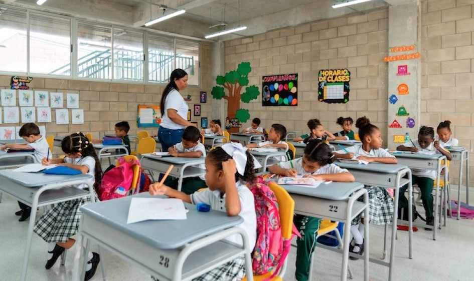 Profesora y estudiantes en un salón de clases.