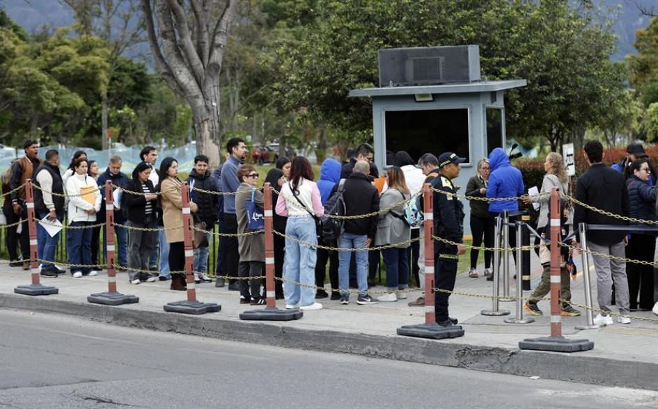 Ciudadanos colombianos esperan en una fila para solicitar la visa de los Estados Unidos este viernes, afuera de la embajada estadounidense en Bogotá (Colombia). 
