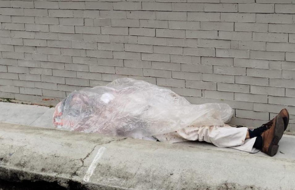 El adulto mayor acostado en un andén, a las afueras del Hospital San Vicente de Paúl de Anserma. 