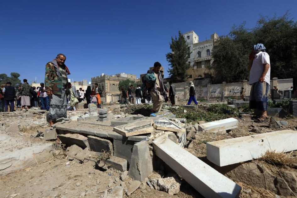Personas inspeccionan el lugar de los ataques aéreos estadounidenses en un cementerio de Saná, Yemen