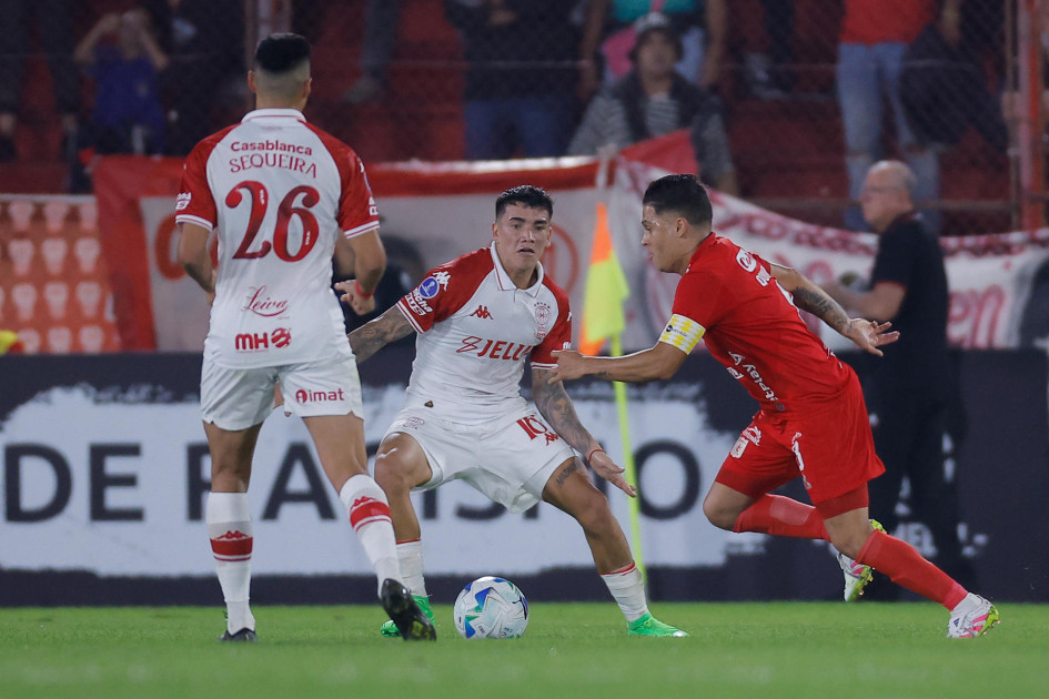 Rodrigo Cabral (c), de Huracán, disputa el balón con Juan Fernando Quintero, de América de Cali, en el partido que el Globo y la Mecha empataron a cero en Buenos Aires.