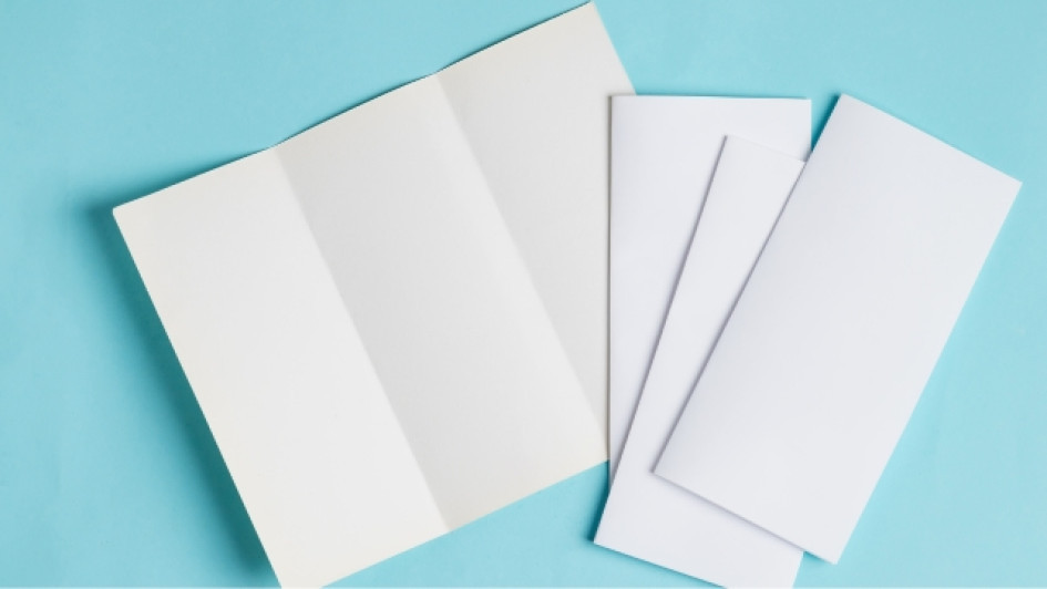 Brochures en blanco sobre una superficie azul.
