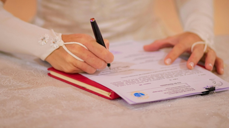 Novia firmando un certificado de matrimonio