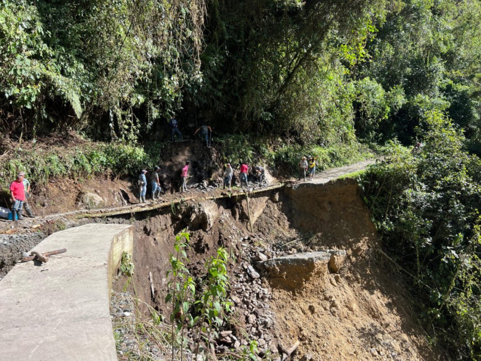 Caminar al lado del vacío es la solución que hallaron ciudadanos en una vía de Caldas, donde construyeron un paso improvisado tras el colapso de la banca.