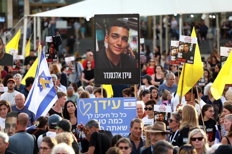 La gente se reúne para ver una transmisión en vivo en una pantalla gigante que informa sobre la liberación del rehén soldado israelí-estadounidense Edan Alexander