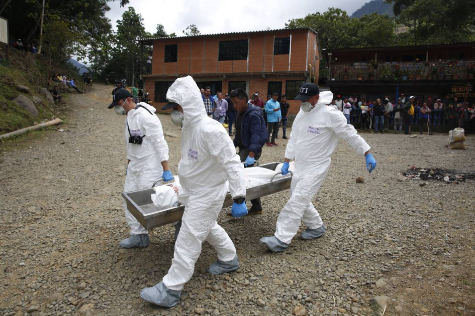 Integrantes de la Policía Judicial colombiana trasladando el cuerpo de una persona fallecida, en un operativo militar contra la minería ilegal, en el corregimiento Pichendé a unos 16 km de Cali. 