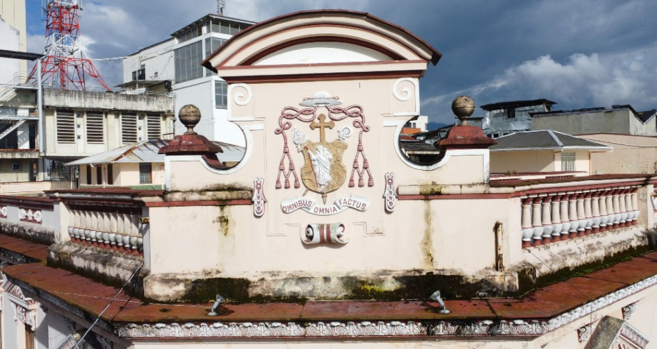 En lo alto de la fachada del Palacio Arzobispal se destaca el escudo episcopal de monseñor Tiberio de Jesús Salazar, obispo de Manizales entre 1922 y 1932, con la frase en latín Omnibus Omnia Factus (Todo lo hecho para todos). Este lema resume el espíritu de servicio de la Iglesia y su papel en la sociedad. Como muchos otros anagramas y escudos del Centro Histórico es símbolo de identidad, linaje y poder en la arquitectura republicana de la ciudad.