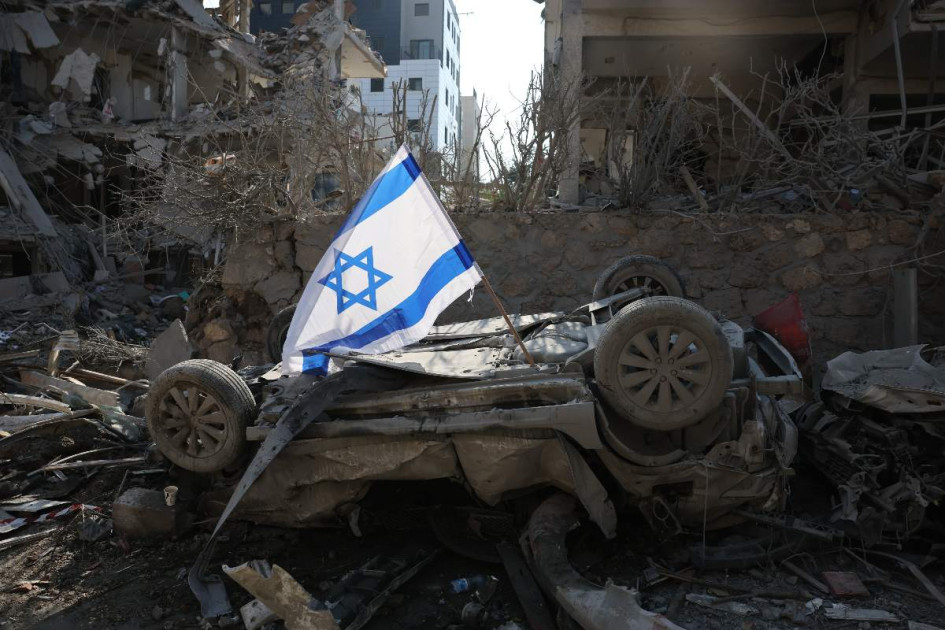 Una bandera israelí colocada sobre un vehículo dañado tras el impacto de un misil en una zona residencial de Ramat Gan, cerca de Tel Aviv, este sábado.