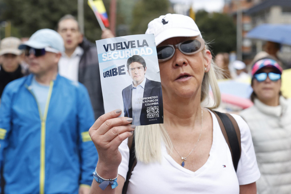 Una mujer sostiene un cartel durante una caminata por la paz y en apoyo al senador Miguel Uribe Turbay, en Bogotá.