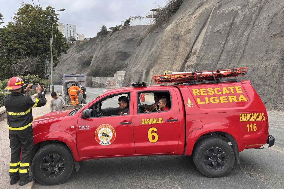 Integrantes de equipos de rescate cierran la avenida Costa Verde por derrumbes en el acantilado, producto del sismo ocurrido este domingo, en Lima (Perú).