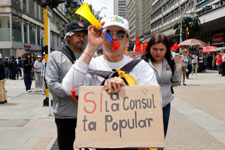 Una mujer sostiene un cartel durante una marcha convocada por las centrales obreras en apoyo a la intención del presidente colombiano, Gustavo Petro