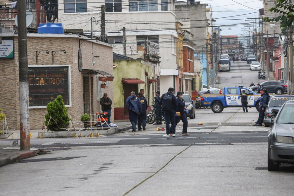 Integrantes del Ministerio Público y agentes de la Policía Nacional Civil custodian la zona donde se registró un ataque armado este miércoles, en Ciudad de Guatemala (Guatemala). 