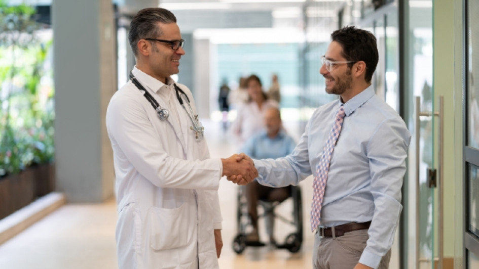 Hombre y un medico se dan la mano en un hospital