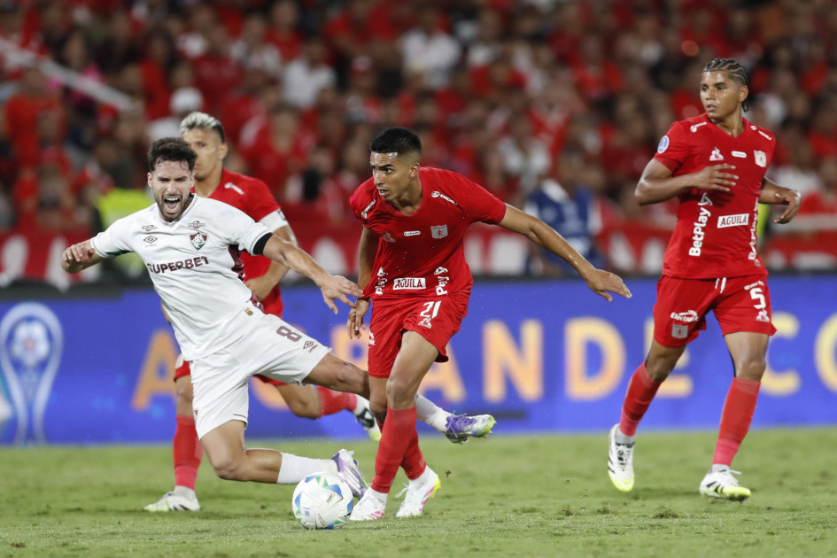 Sebastián Navarro (centro), del América de Cali, disputa el balón con Matheus Martinelli (izq.), de Fluminense.