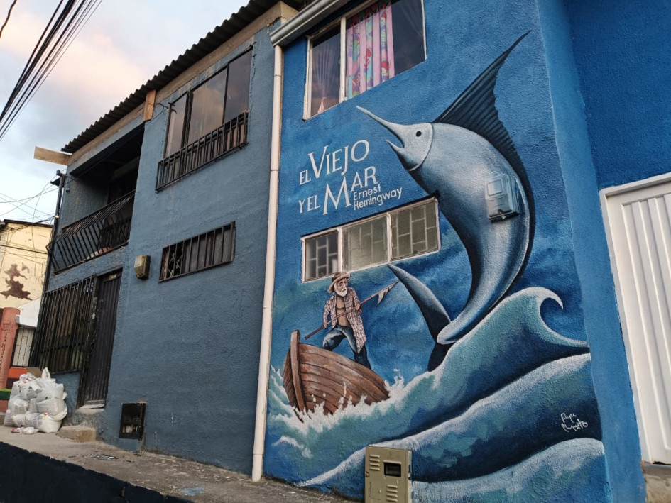 Portada de El viejo y el mar pintada en una fachada de La Pradera, obra de Felipe Chiquito, artista local de Villamaría.