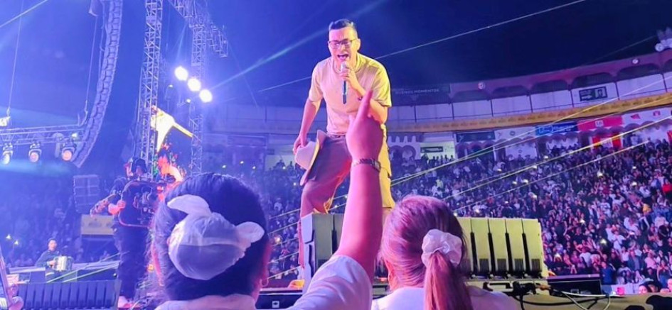 Claudio Orozco, levanta la mano, mientras Yeisón Jiménez le canta durante su concierto en la Plaza de Toros de Manizales. 