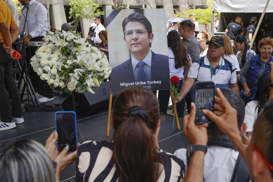 Personas toman fotografías a una imagen del fallecido senador y precandidato de Colombia Miguel Uribe Turbay, durante un homenaje este martes, en Medellín (Colombia)