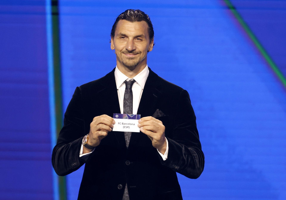 El exfutbolista sueco Zlatan Ibrahimovic sostiene el papel del Barcelona durante el sorteo de la fase de liga de la UEFA Champions League en el Foro Grimaldi de Mónaco.